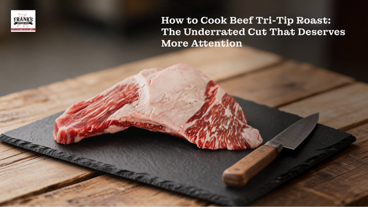 Raw beef tri-tip roast with visible marbling on slate board with chef's knife, Frank's Butcher Shop.